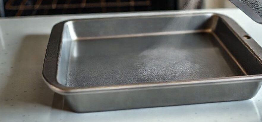 Vaporisation d'un spray de cuisson dans un moule à gâteau de 20x20 cm